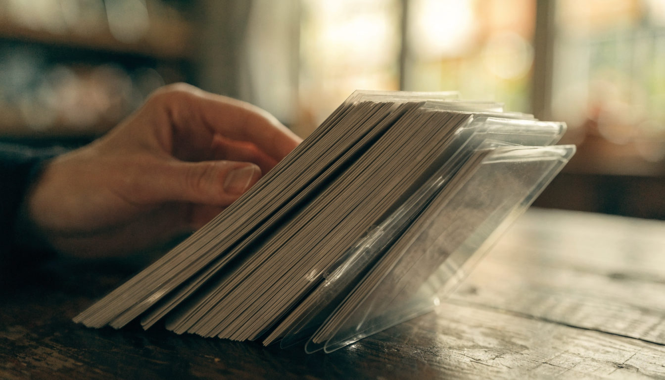 Aufgefächerte Sammelkarten von der Rückseite auf einem Holztisch, warmes Licht