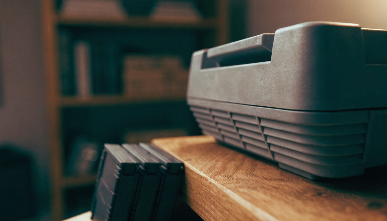 Anonyme graue 16-Bit-Retro-Konsole von der Seite auf Holzregal, ohne Markenlogo